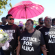 Charity Oriakhi, center, widow of Nigerian street vendor Alika Ogorchukwu, attends a demonstration to demand justice for her husband in Civitanova Marche, Italy, Saturday, Aug. 6, 2022.